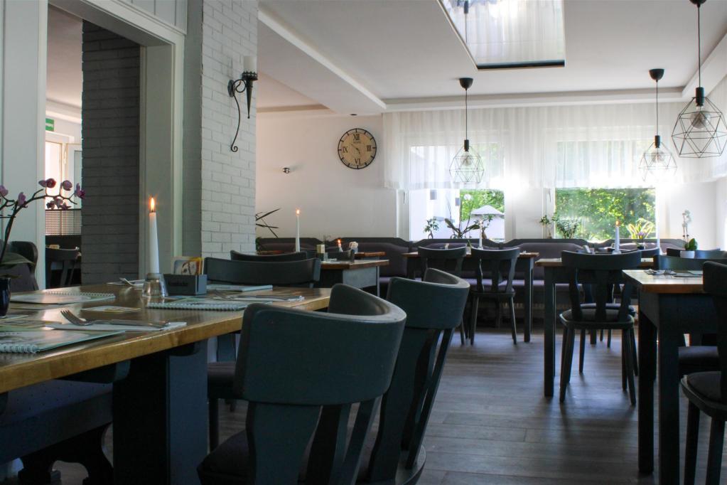 Das Bild zeigt den Innenraum des Restaurants mit brennenden Kerzen auf den Tischen, aus einer anderen Ecke fotografiert