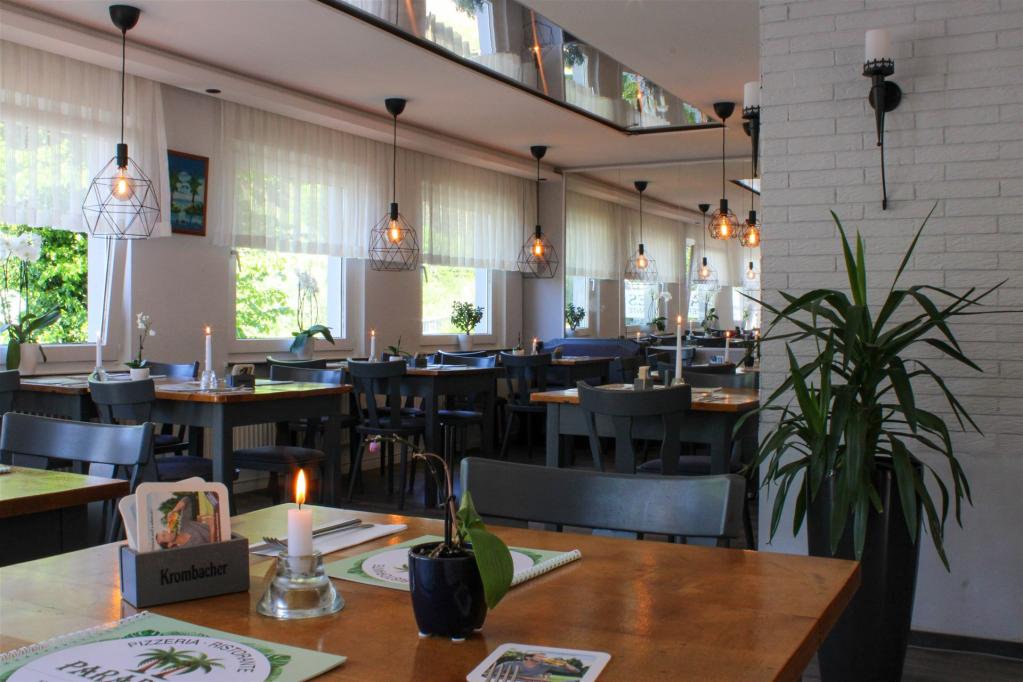 Das Bild zeigt den Innenraum des Restaurants mit brennenden Kerzen auf den Tischen